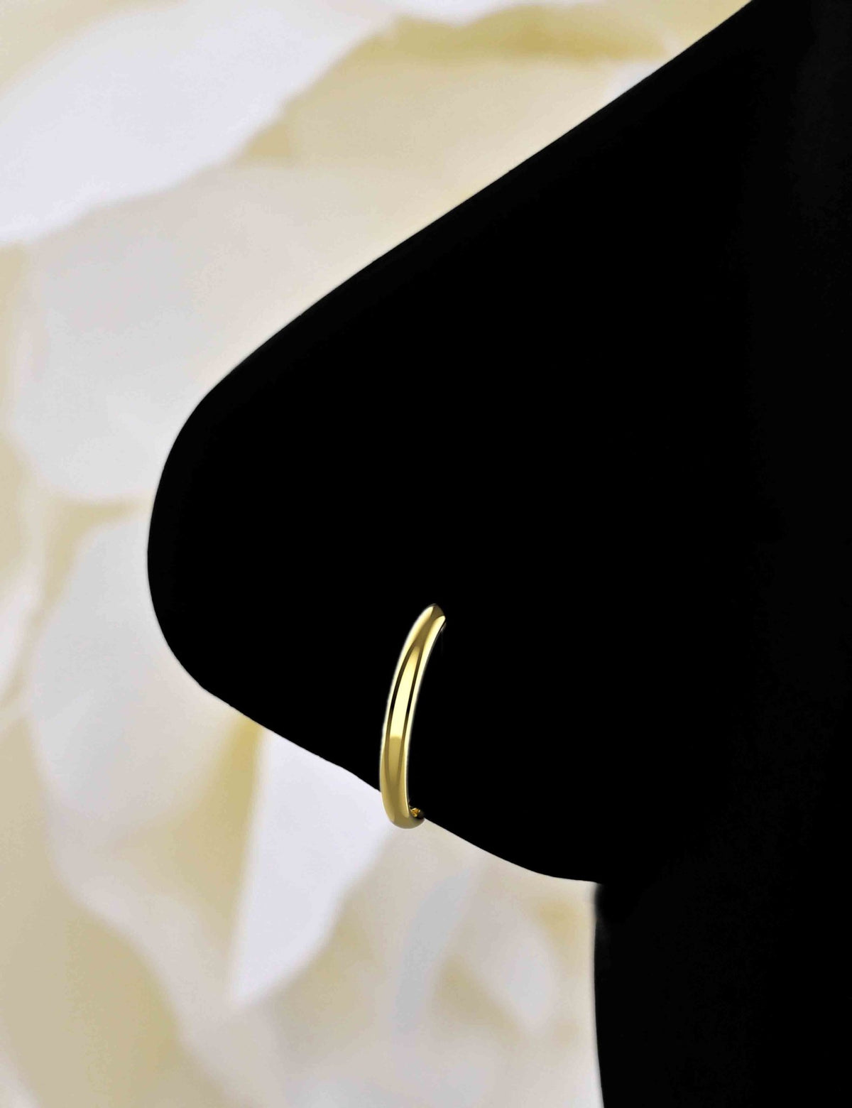 Gold-finish hoop nose ring worn on the nose